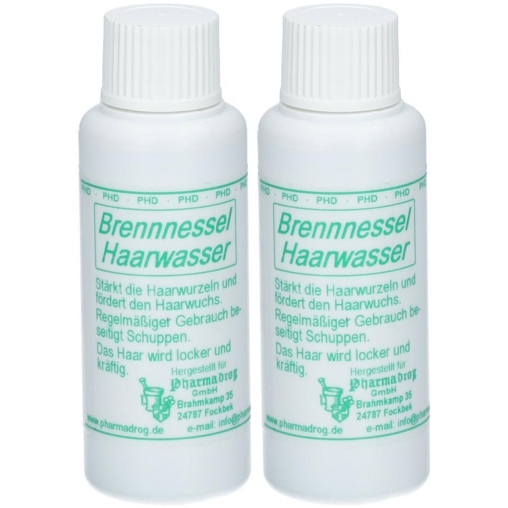 Zwei weiße Flaschen mit Schraubverschluss. Aufschrift: Brennnessel Haarwasser. Text in grüner Schrift. Hersteller: Pharmadrog.