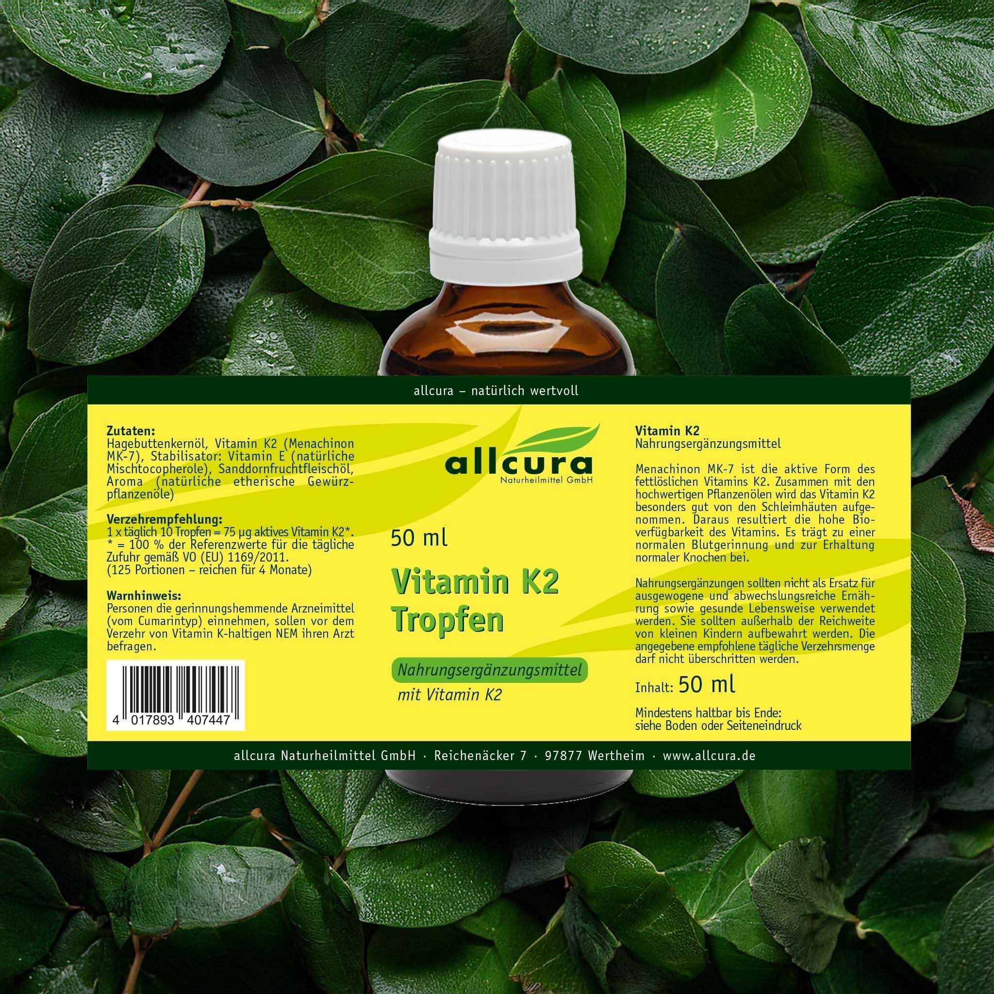 Braune Glasflasche mit weißem Deckel, Etikett mit "Vitamin K2 Tropfen" und "allcura". Liegt auf Blättern.