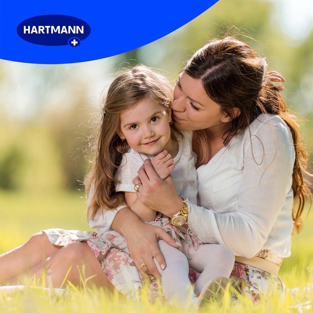 Frau und Kind im Gras. Frau umarmt Kind. Natürlicher Hintergrund.