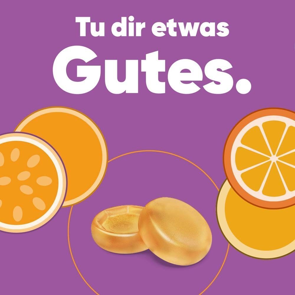 Zwei ipalat® Vitaminpastillen und Fruchtscheiben von Orange und Maracuja auf lila Hintergrund.