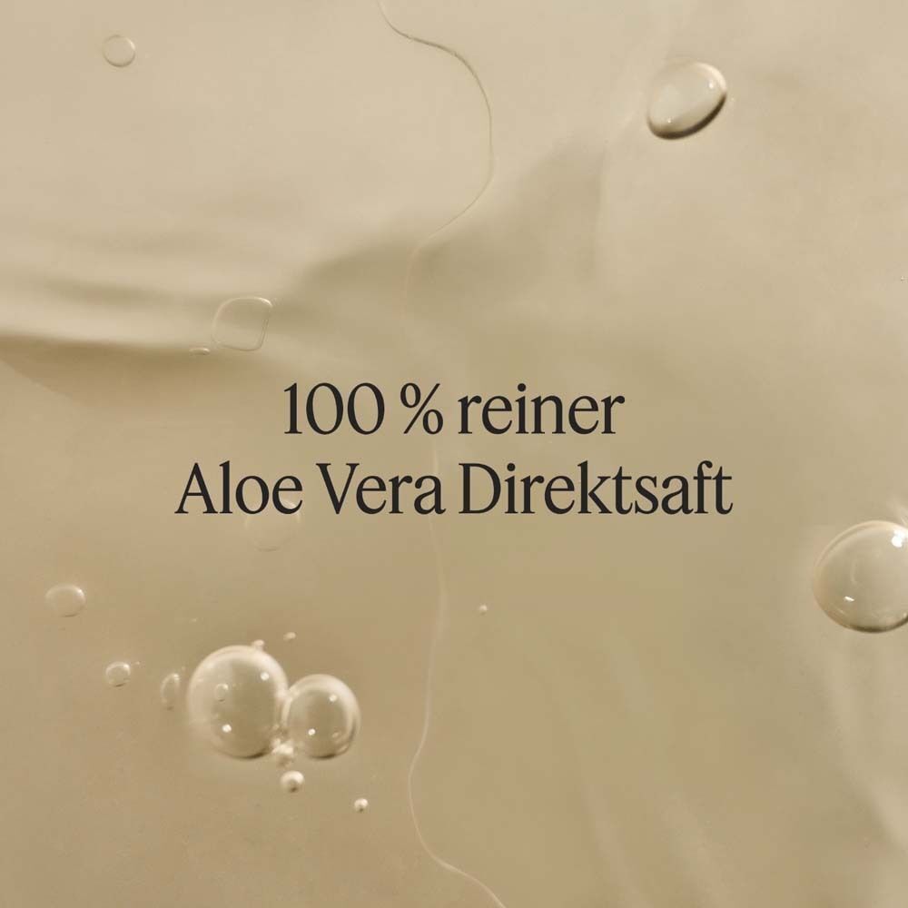 Nahaufnahme von SANTAVERDE Aloe Vera Saft mit Luftblasen und Wassertropfen.