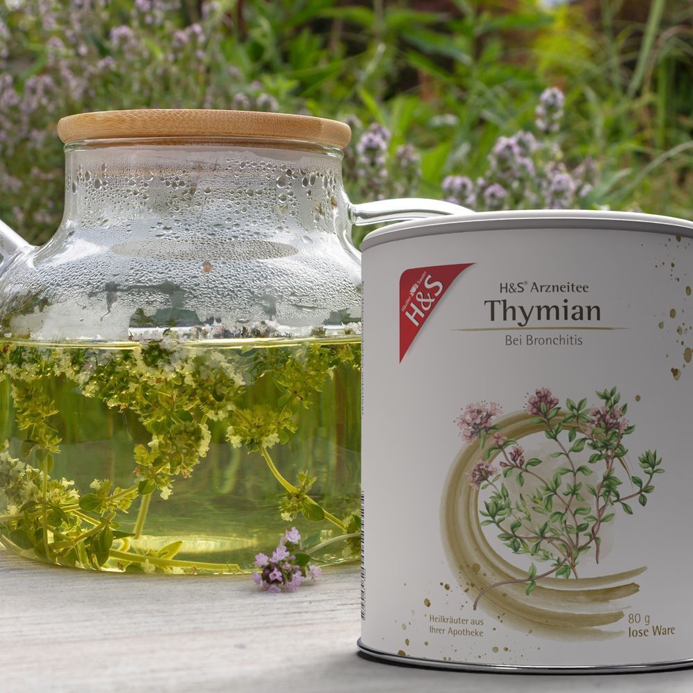 Dose H&S® Thymian loser Tee neben einer Teekanne mit aufgebrühtem Thymiantee.