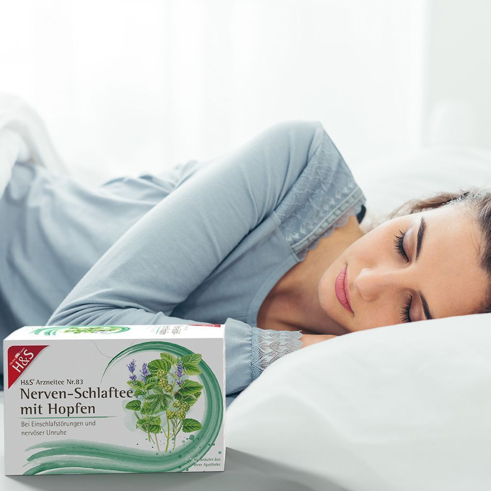 Eine Frau schläft im Bett, daneben eine Packung H&S Nerven-Schlaftee mit Hopfen.
