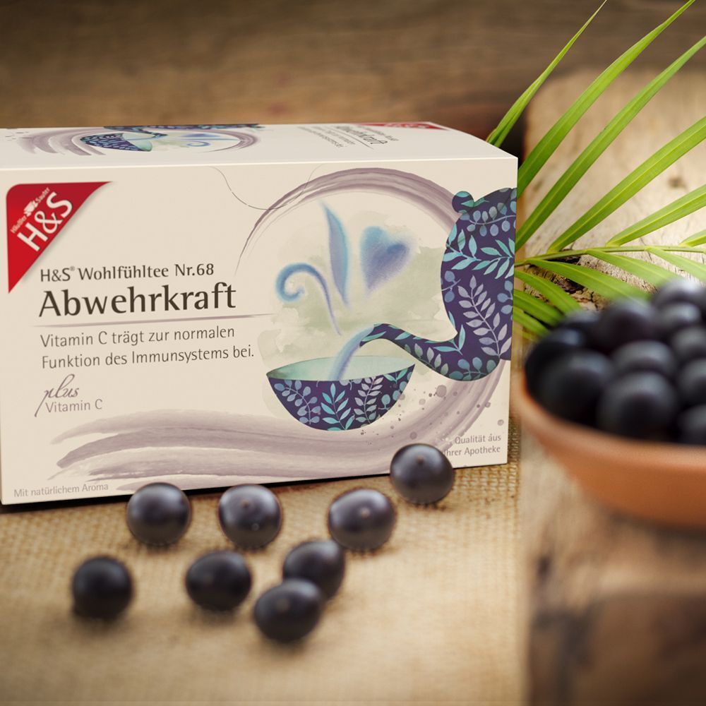H&S Abwehrkraft Tee-Packung. Weiße Verpackung mit Logo und Produktinformationen. Teekanne und Tasse abgebildet. Beeren daneben.