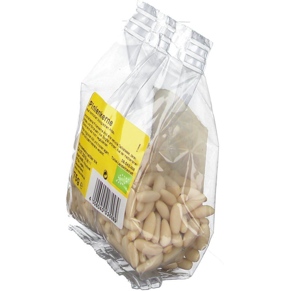 Transparenter Beutel mit Pinienkernen. Gelbes Etikett mit "RAPUNZEL" und "Pinienkerne". 75g. Bio-Siegel. Beutel leicht schräg.
