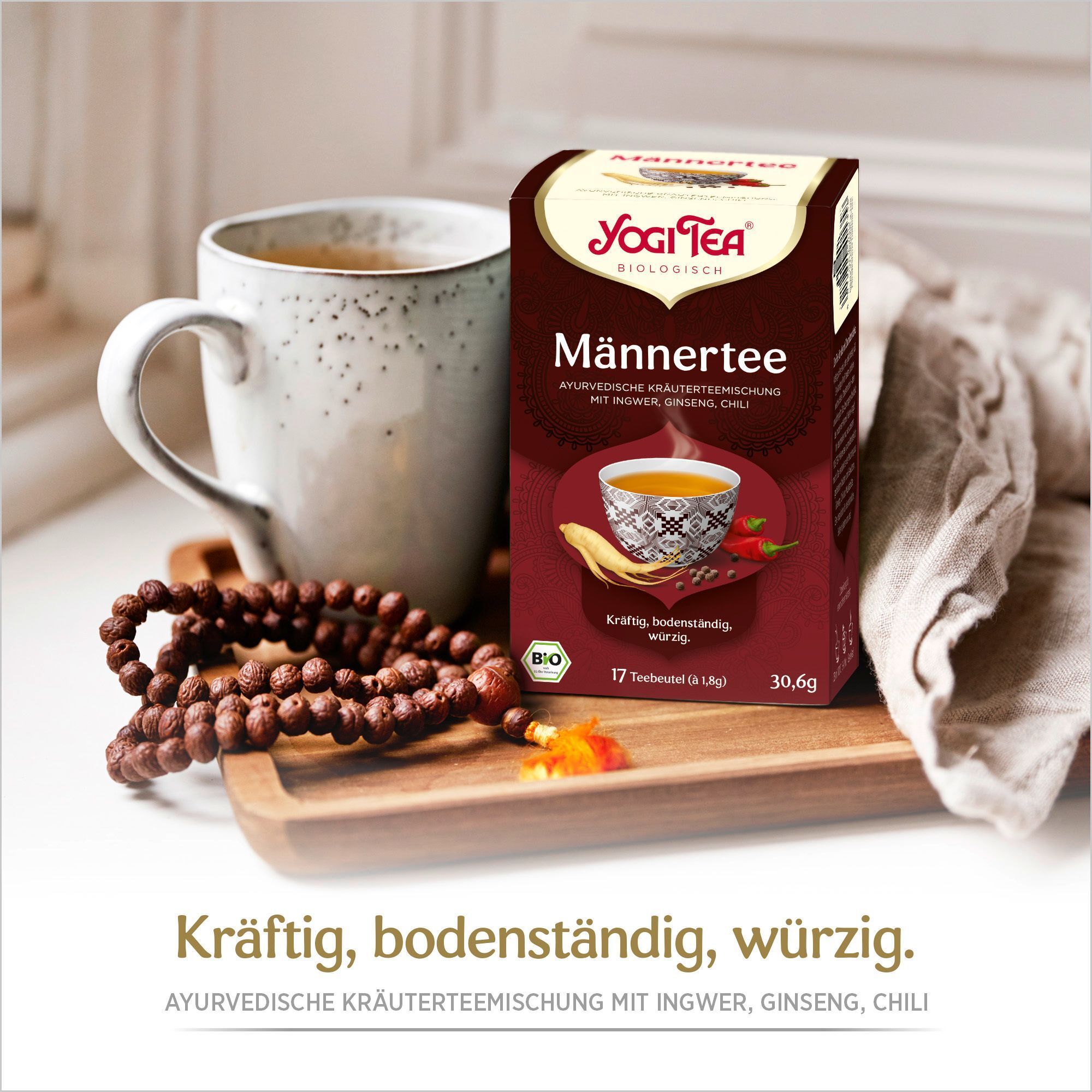 YOGI TEA Männer Tee Bio Filterbeutel Packung neben einer Tasse Tee. Aufdruck: Männertee, ayurvedische Kräutermischung, 17 Teebeutel, Bio-Siegel.