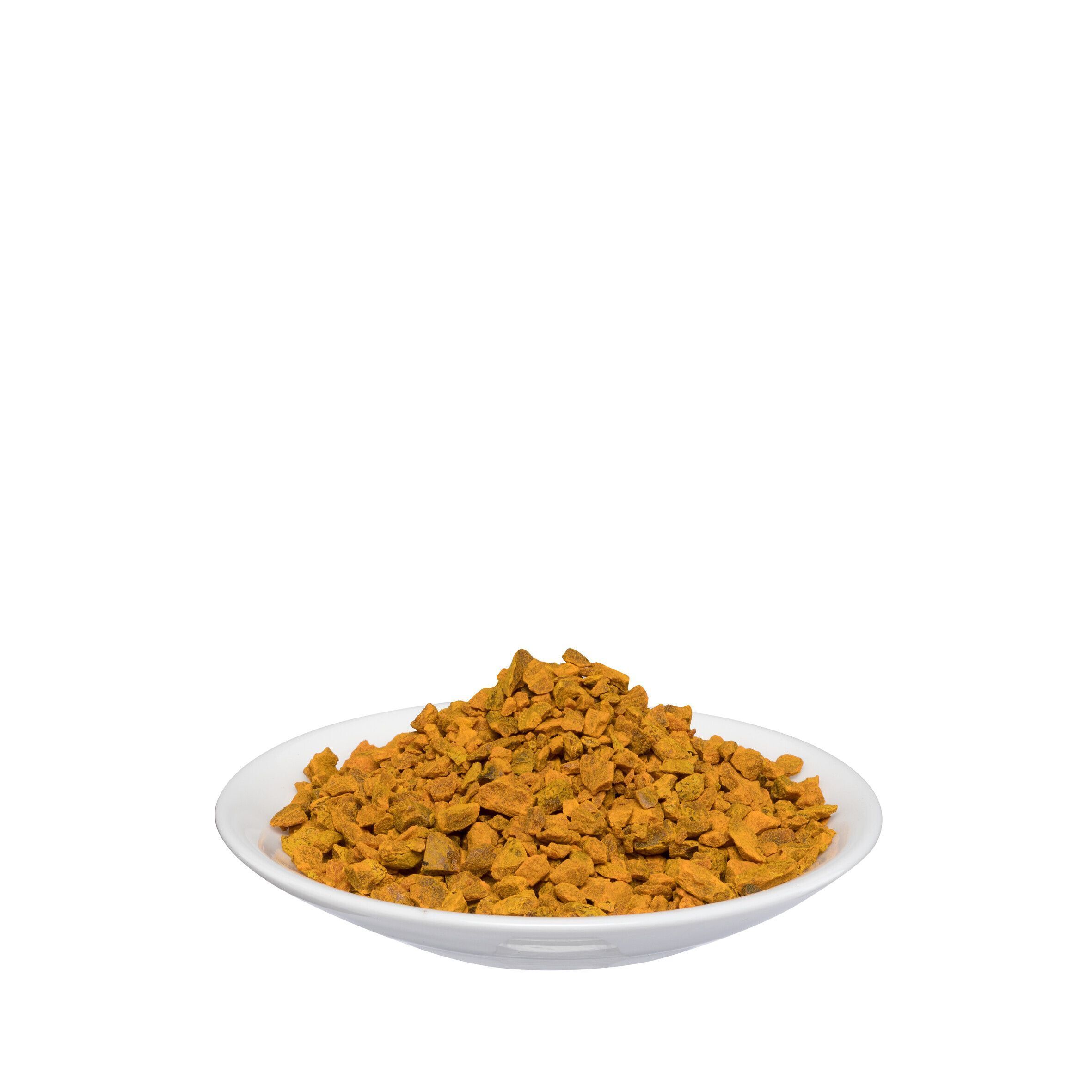 Weißer Teller mit Kurkumapulver. Gelb-orangefarbenes Pulver.