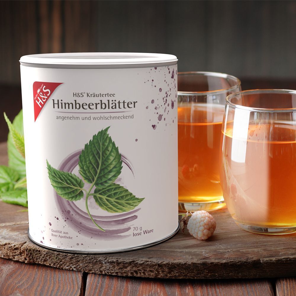 Dose H&S Himbeerblätter Tee neben zwei Gläsern Tee. Dose mit rotem Logo und grünen Blättern. Text: H&S Kräutertee, Himbeerblätter.