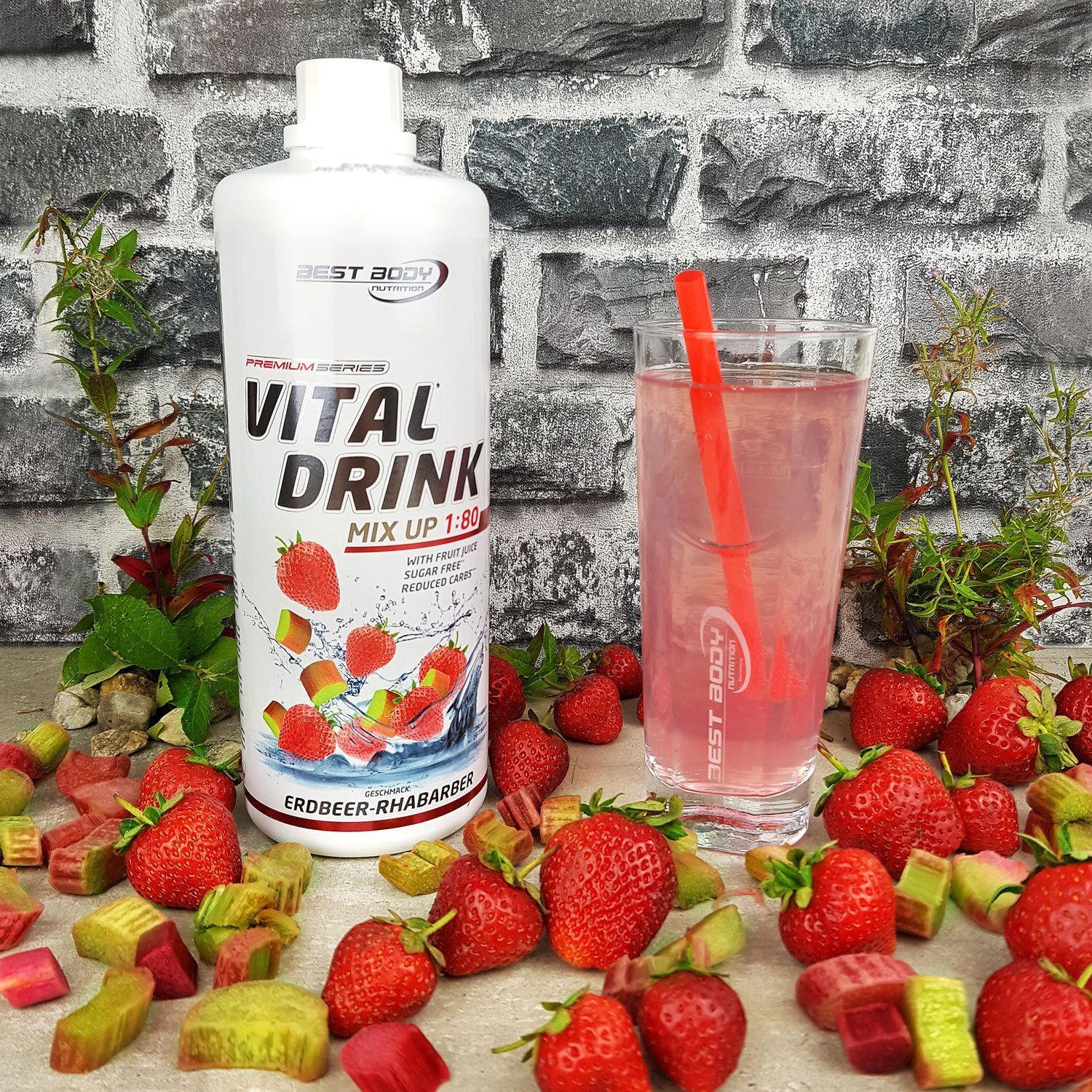 Flasche BBN Vital Drink neben einem Glas Getränk. Erdbeeren und Rhabarberstücke umgeben die Szene. Roter Strohhalm.