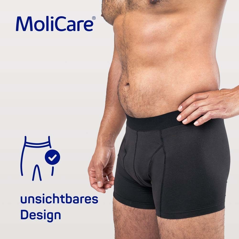 Mann in schwarzer MoliCare MEN Boxershorts. Text: unsichtbares Design. Logo: Boxershorts mit Haken.