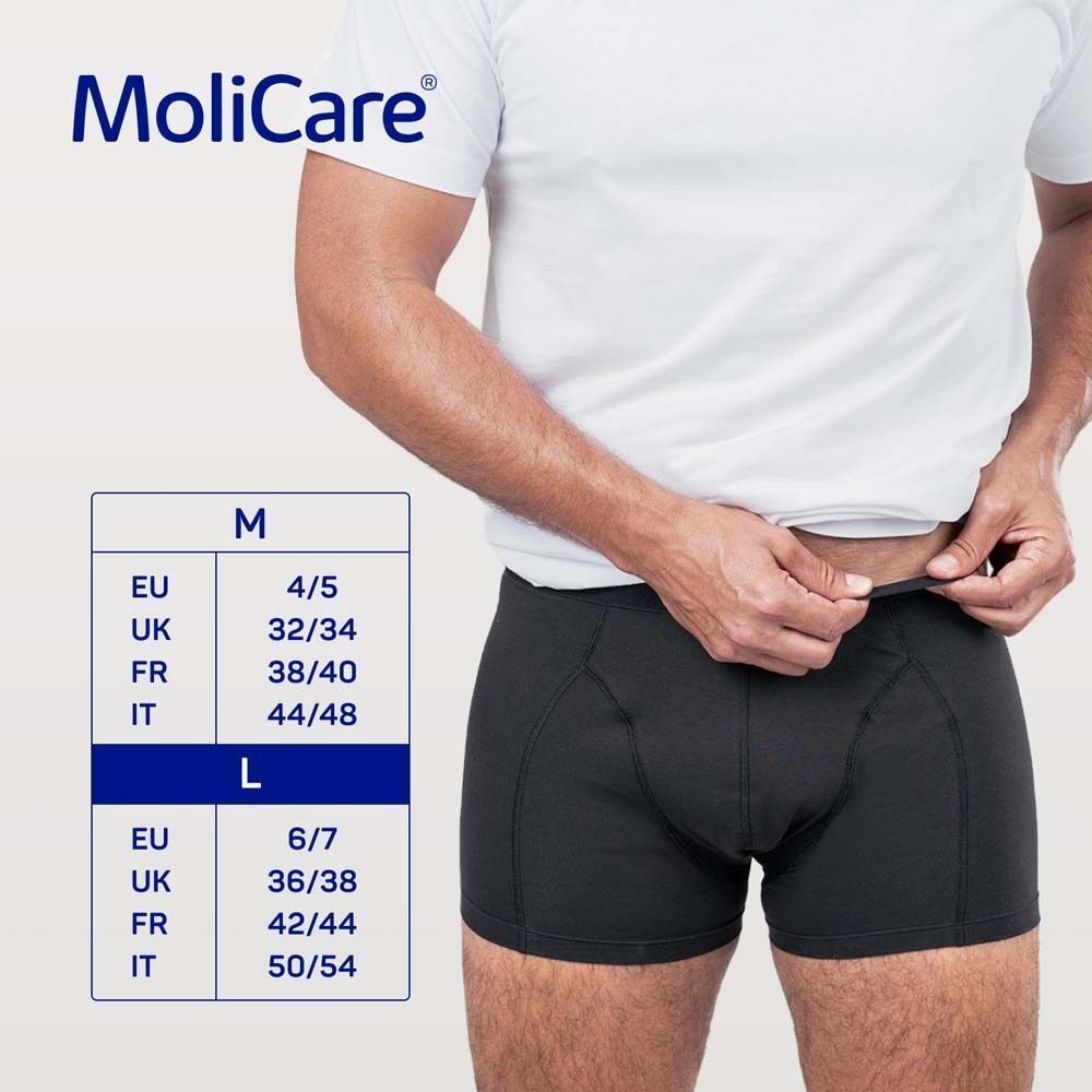 Mann in schwarzer MoliCare MEN Boxershorts. Größentabelle: EU, UK, FR, IT. Größen M und L.