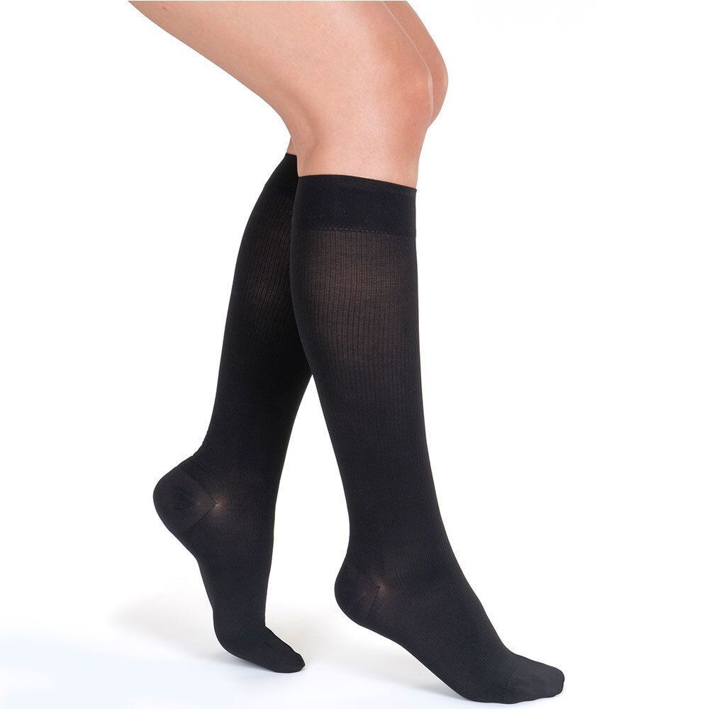 Person trägt schwarze Kniestrümpfe. Die Strümpfe bedecken den Fuß und reichen bis unter das Knie.