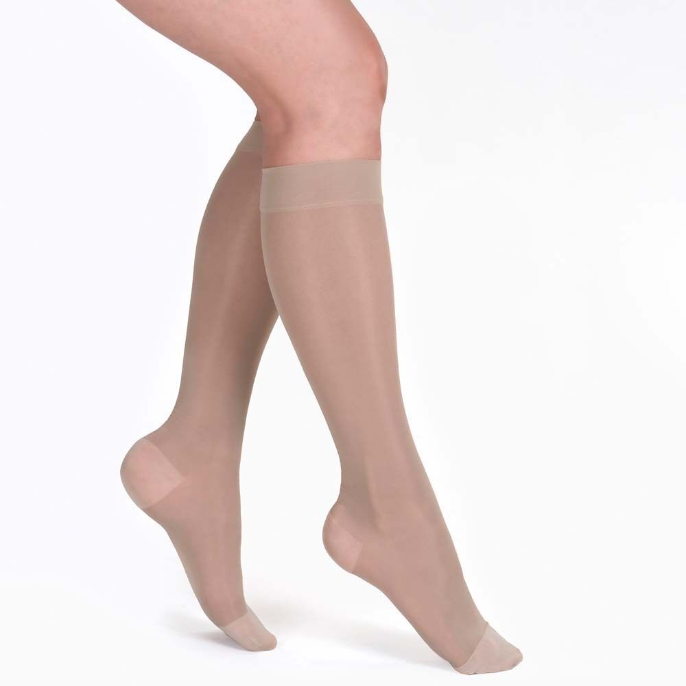 Beine mit transparenten, hautfarbenen Kniestrümpfen. Zehen- und Fersenbereich verstärkt. Strümpfe reichen bis unter das Knie.