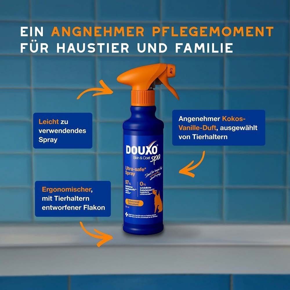 Eine blaue Sprühflasche mit orangefarbenem Sprühkopf. Text: DOUXO Skin & Coat spa, Ultra-safe Spray. Pfeile zeigen auf Details.