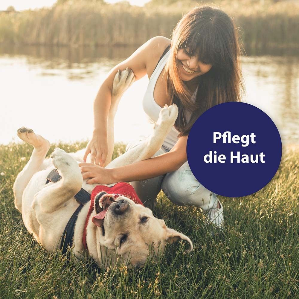 Frau und Hund auf Wiese. Text: Pflegt die Haut.