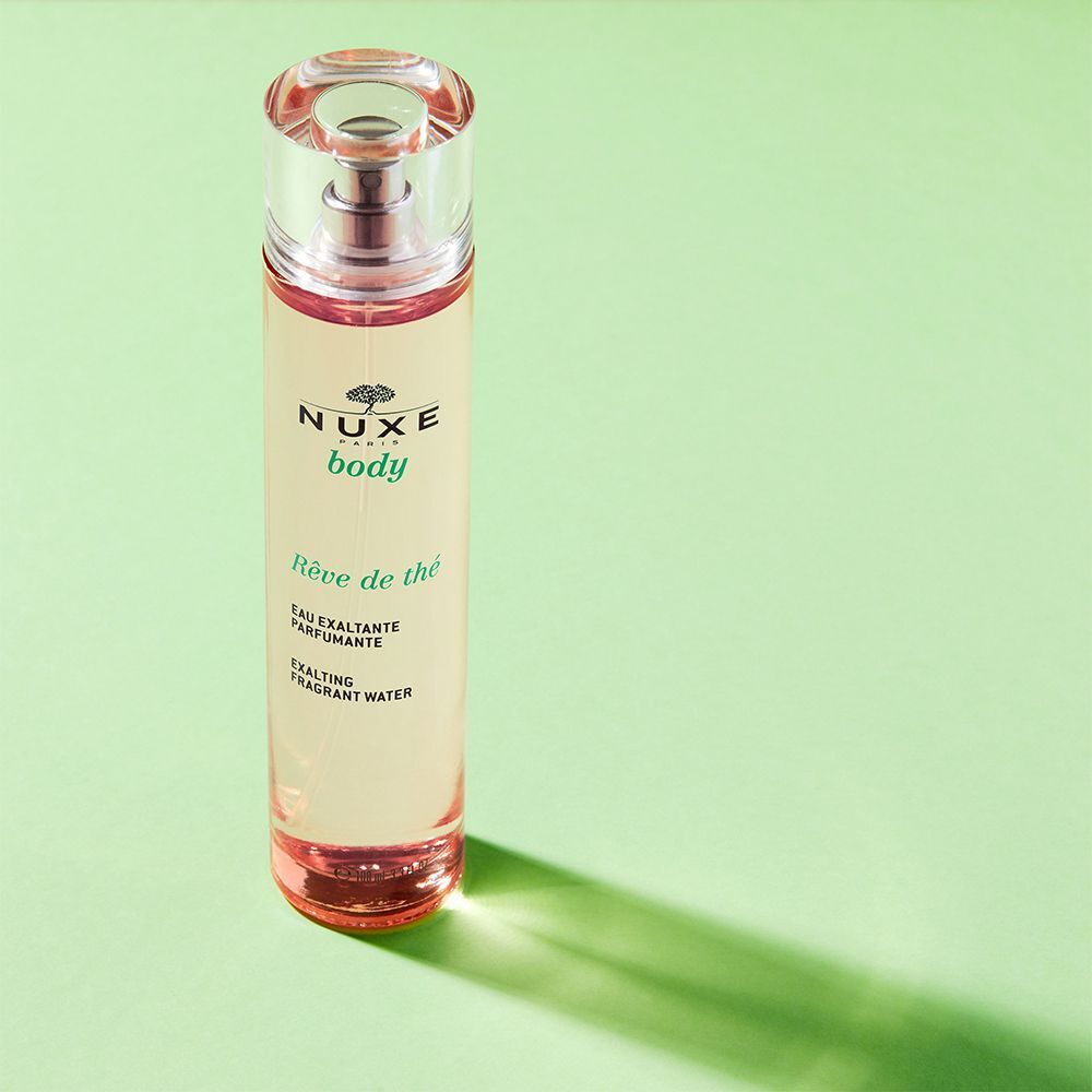 Nuxe Rêve de thé Flasche mit Zerstäuber auf grünem Hintergrund.
