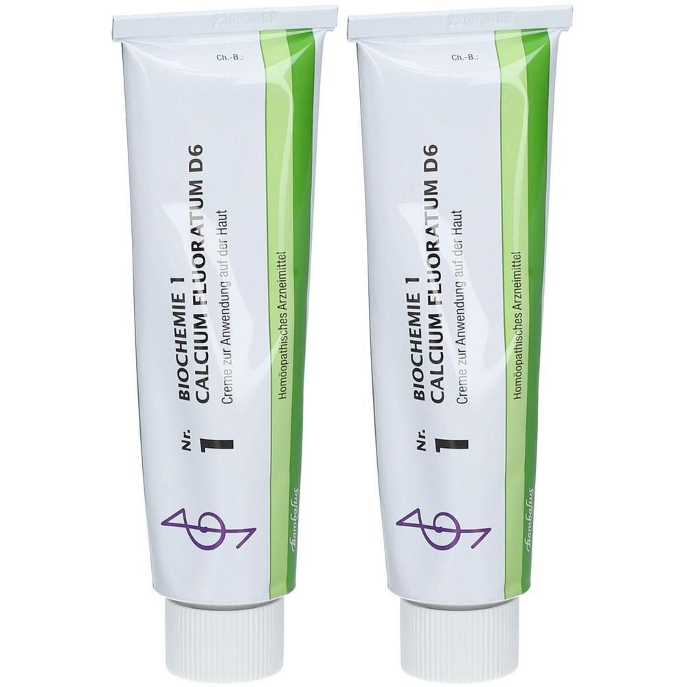 Zwei Tuben Creme. Weiß, mit grünen und schwarzen Schriftzügen. Aufschrift: BIOCHEMIE 1 CALCIUM FLUORATUM D6. Homöopathisches Arzneimittel.