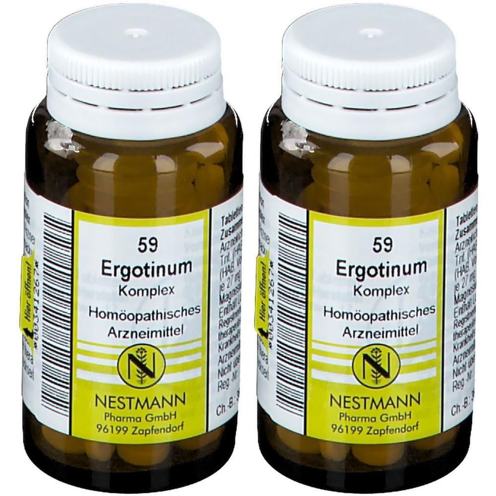 Zwei braune Glasflaschen mit weißen Verschlüssen, gefüllt mit kleinen gelben Tabletten. Etiketten zeigen "Ergotinum Komplex".