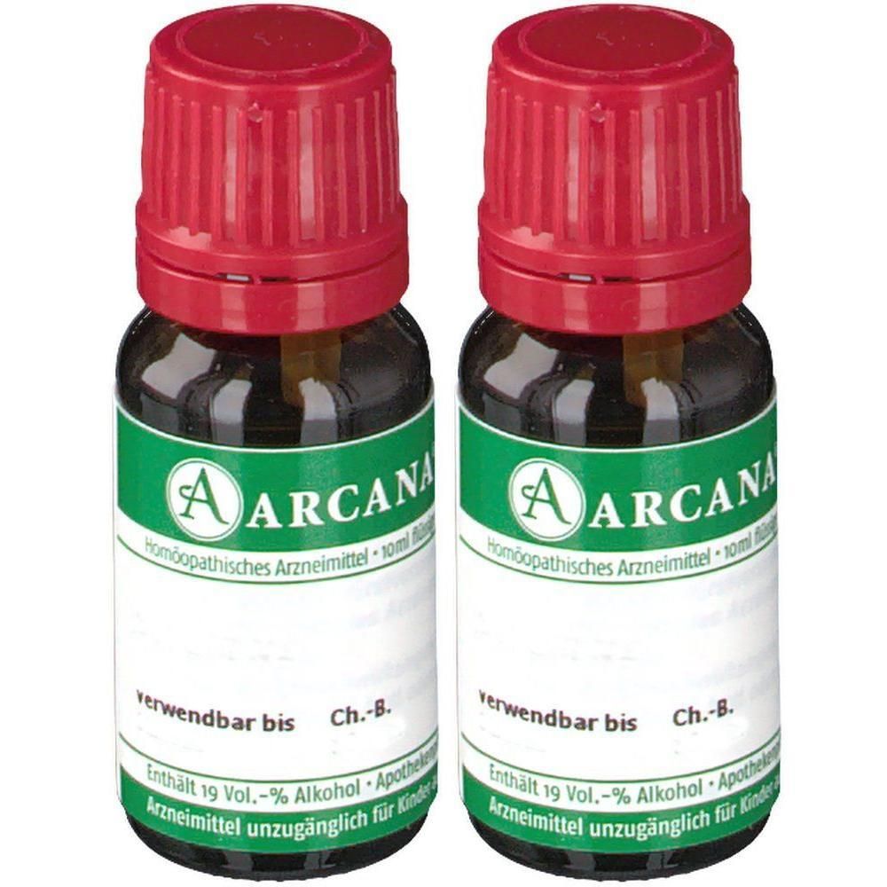 Zwei kleine braune Glasflaschen mit rotem Schraubverschluss, Etikett mit 'ARCANA' und 'Homöopathisches Arzneimittel'.