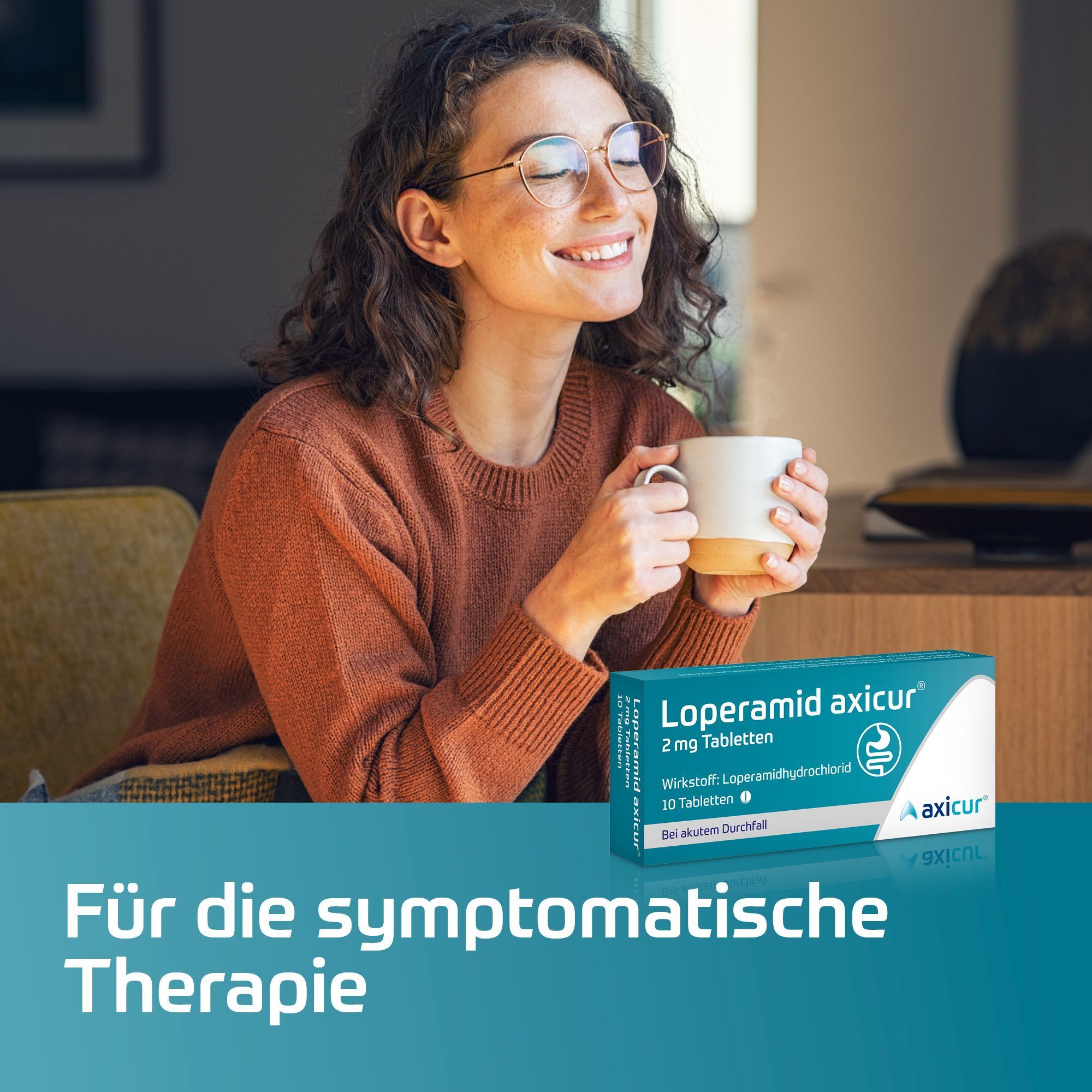 Packung Loperamid axicur® 2 mg Tabletten neben einer lächelnden Frau, die eine Tasse hält.