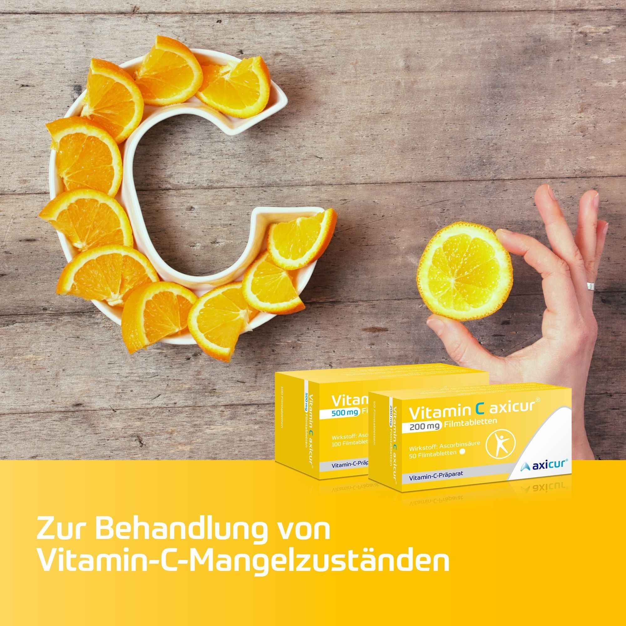 Packungen Vitamin C axicur® neben einer Hand, die eine Orangenscheibe hält, und einer "C"-Form aus Orangenscheiben.