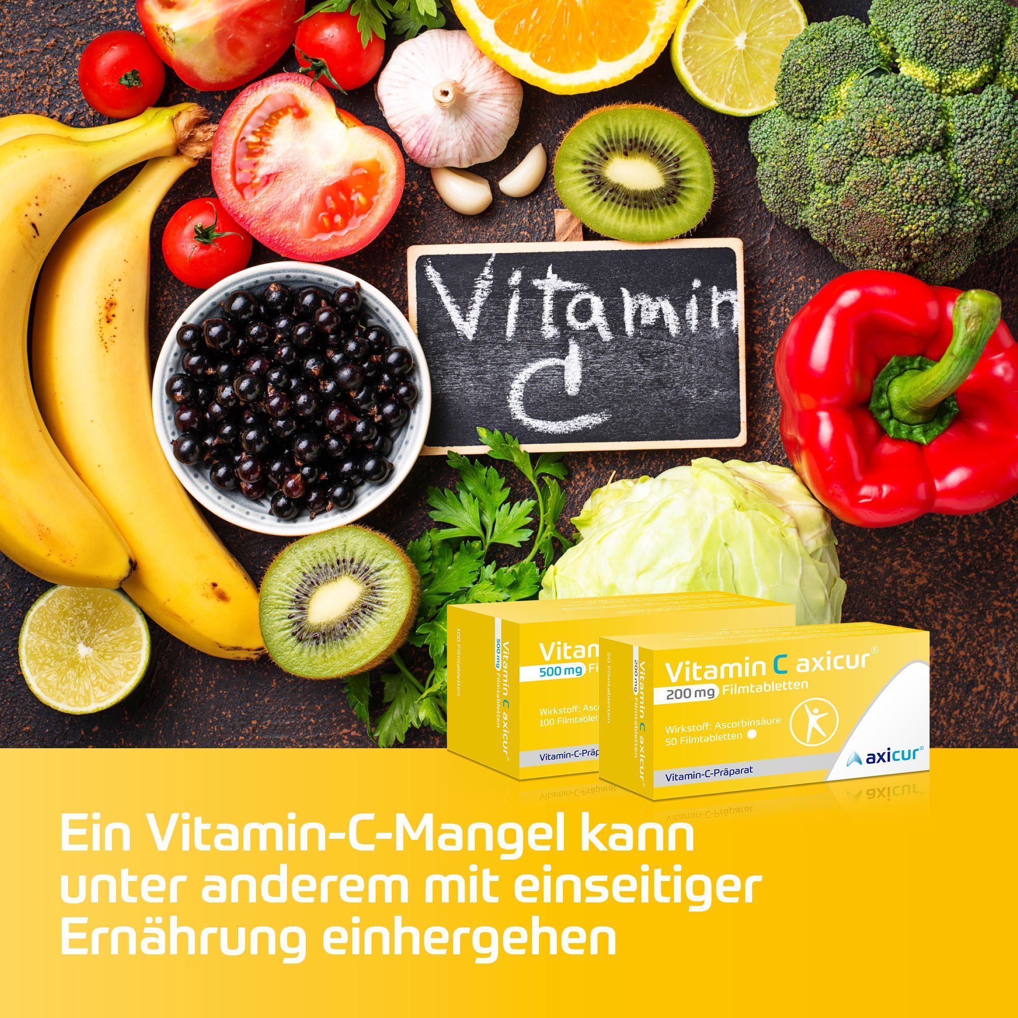 Packungen Vitamin C axicur® inmitten von Obst und Gemüse, mit der Aufschrift "Vitamin C" auf einer Tafel.
