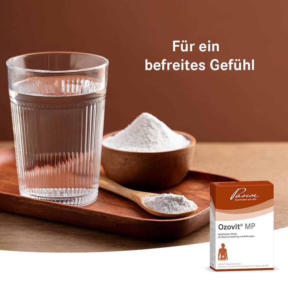 Glas Wasser, Schale mit Pulver, Löffel, Holztablett. Text: Für ein befreites Gefühl. Braune Schachtel Ozovit® MP. Logo Pascoe. Spezifisches Mittel.