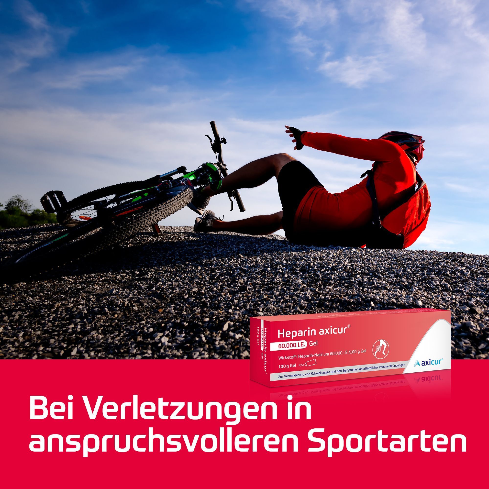 Gestürzter Radfahrer neben Schotter, daneben eine Packung Heparin axicur® Gel.