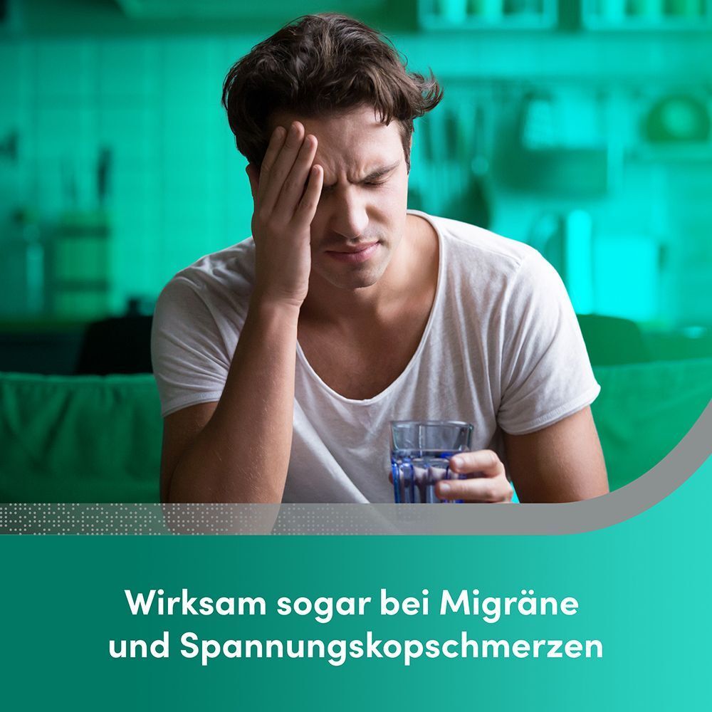 Mann mit Kopfschmerzen hält ein Glas Wasser.