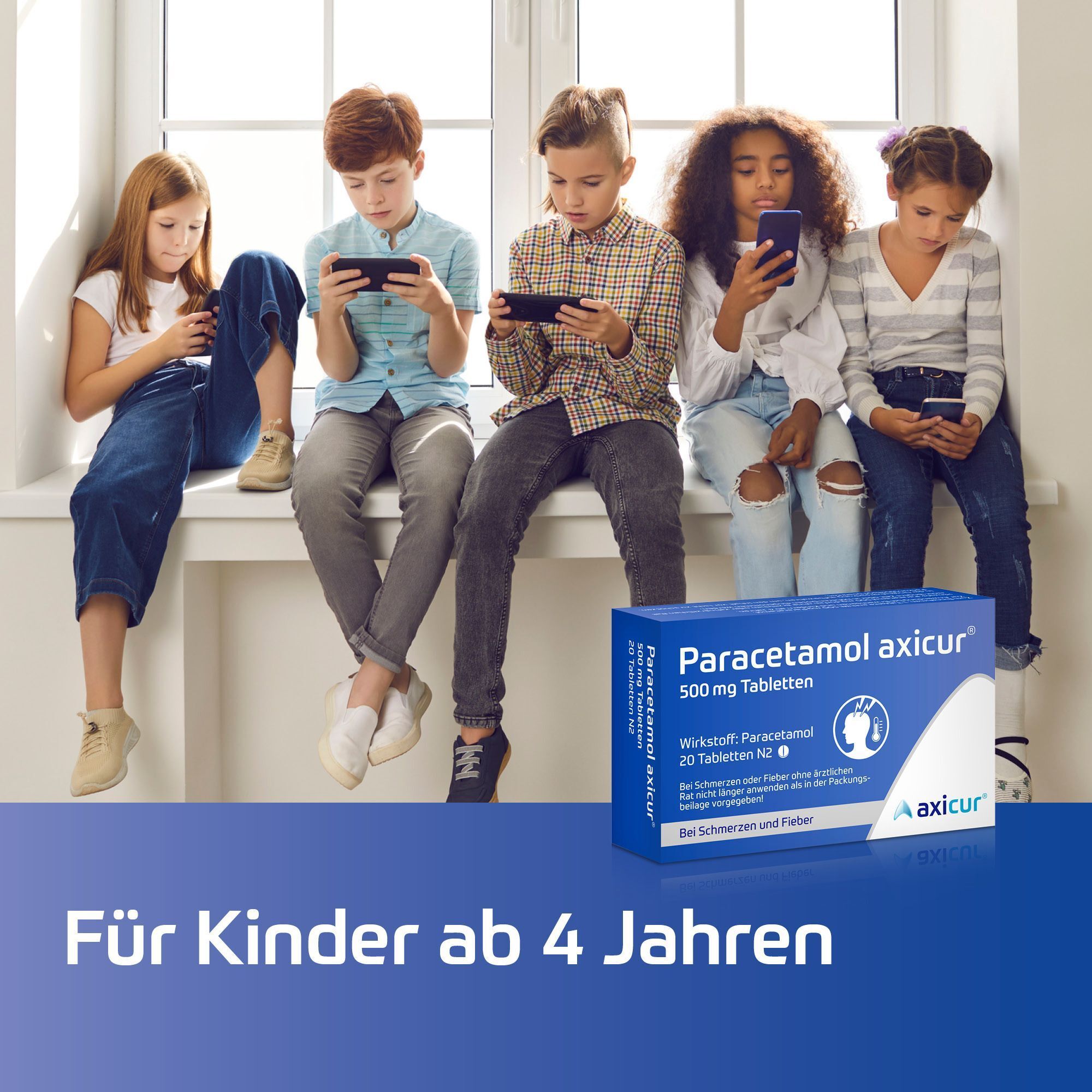 Fünf Kinder sitzen auf einer Fensterbank und schauen auf ihre Handys, daneben Packung Paracetamol axicur® 500 mg Tabletten.