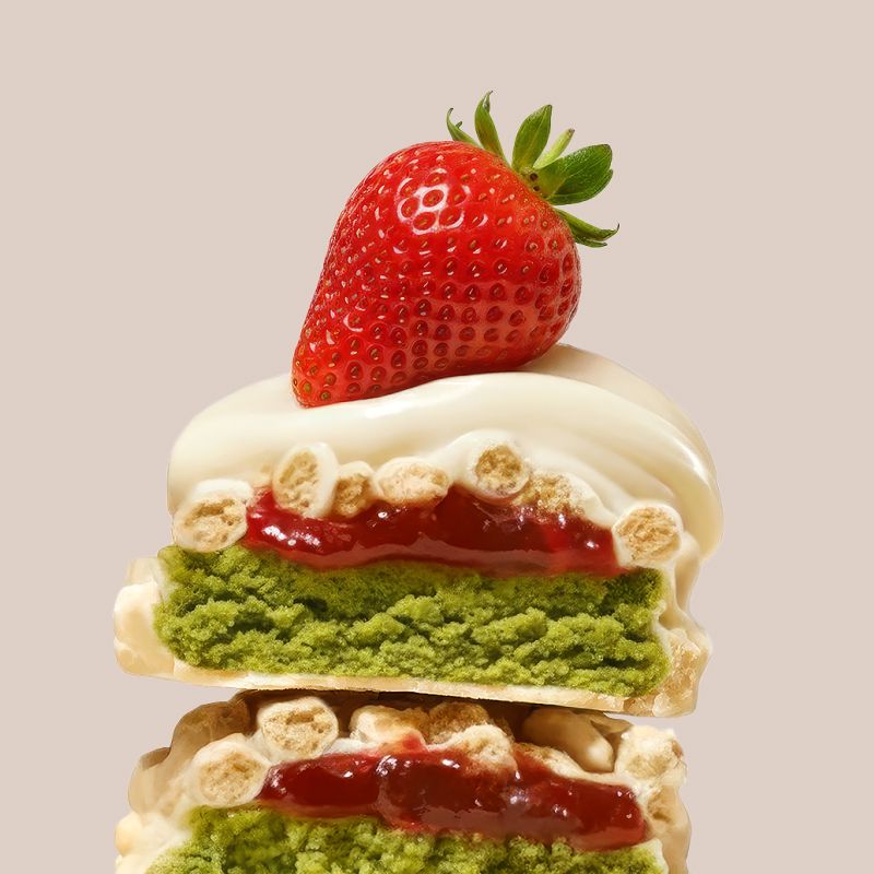 Detailansicht eines Erdbeer-Matcha Proteinriegels mit weißer Schokolade, Erdbeere und Matcha-Füllung.