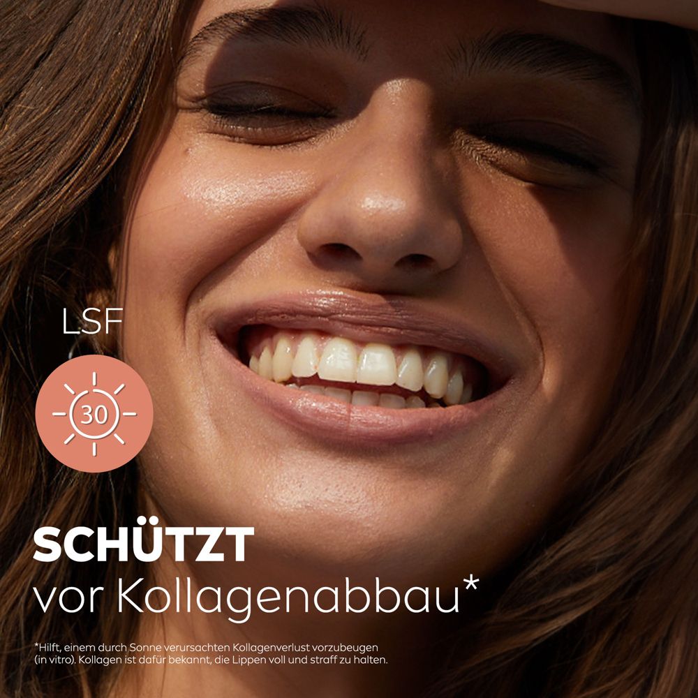 Frau lächelt mit geschlossenen Augen, Labello Caring Beauty NUDE schützt vor Kollagenabbau.