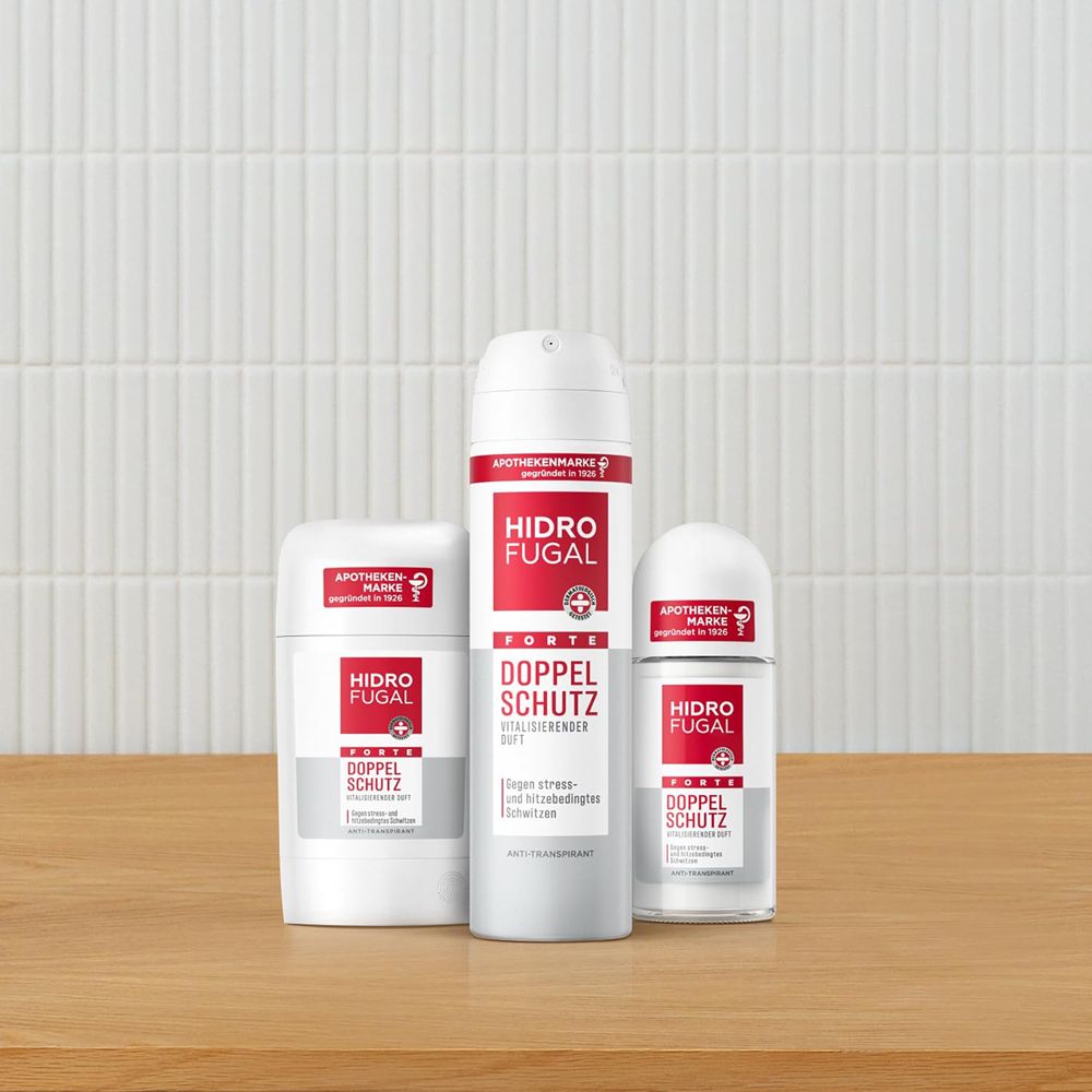 Drei Hidrofugal Produkte: Antitranspirant-Stick, Spray und Roll-on auf Holztisch.