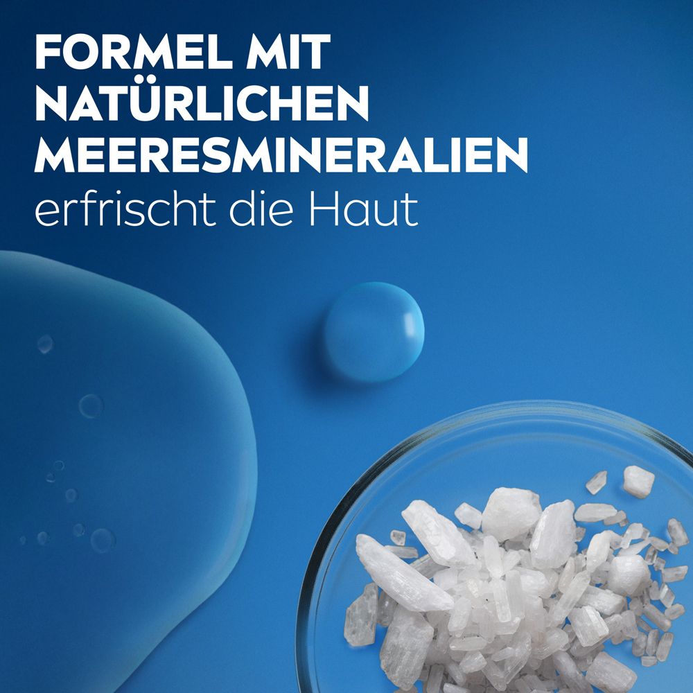 Kristalle von Meeresmineralien in einer Petrischale, daneben eine blaue Flüssigkeit.