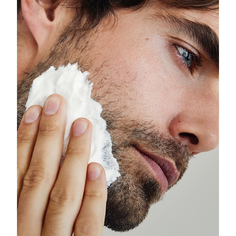 Mann trägt NIVEA MEN Sensitive Rasierschaum auf sein Gesicht auf.