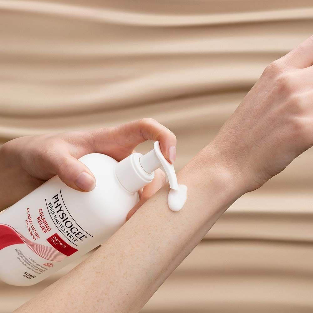 Eine Hand drückt Lotion aus einem Pumpspender auf den Unterarm.