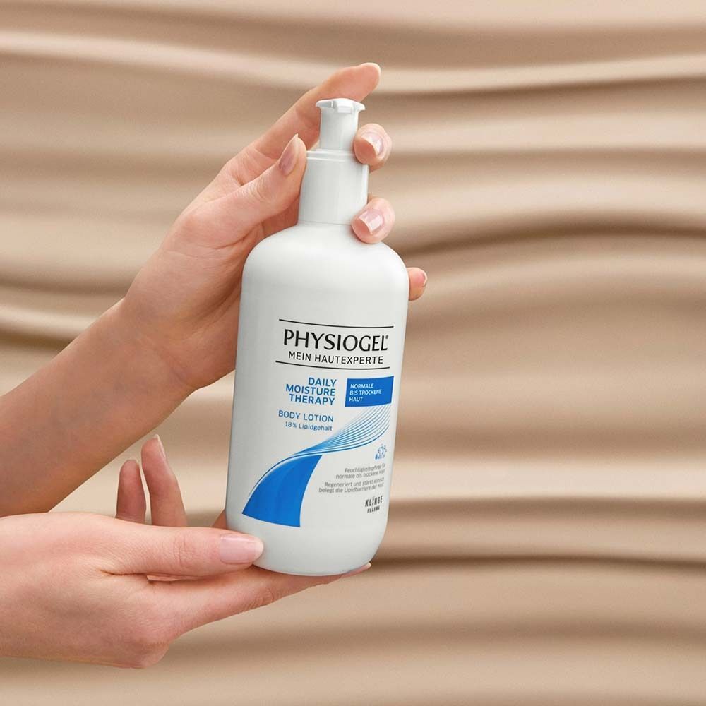 Hände halten eine weiße Pumpflasche PHYSIOGEL® Daily Moisture Therapy Body Lotion.