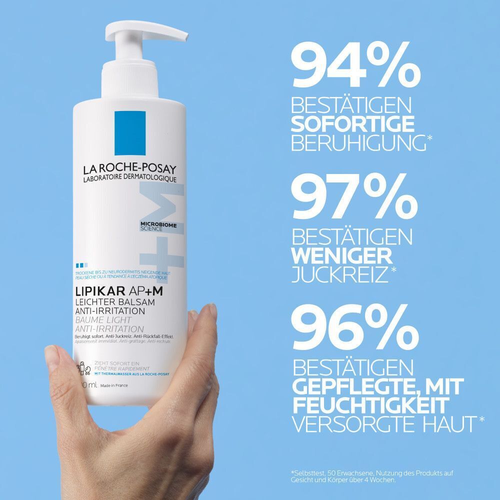 Hand hält La Roche Posay Lipikar Leichter Balsam AP+M Flasche mit Pumpe.