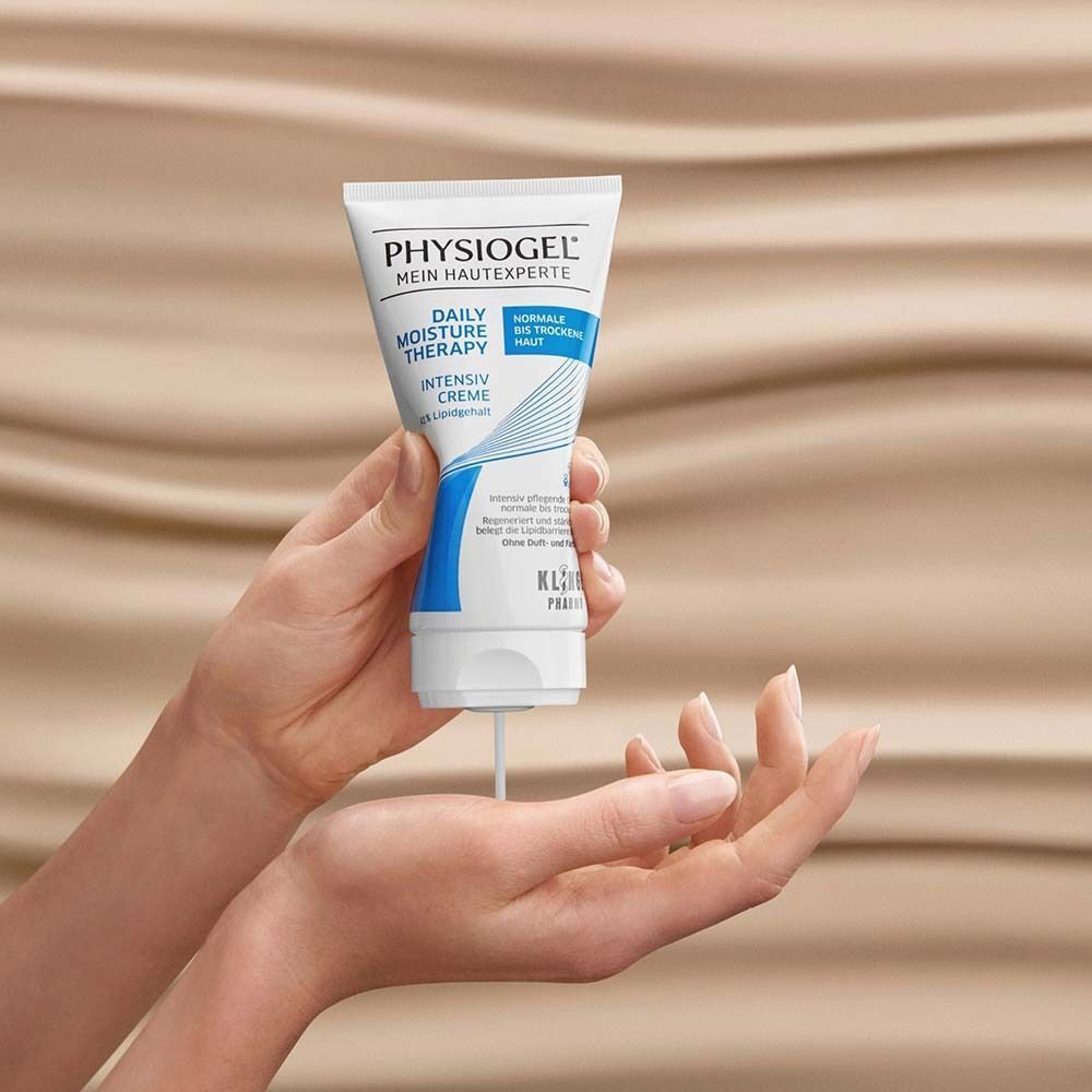 Hände halten eine Tube PHYSIogel Intensiv Creme, Creme fließt heraus.