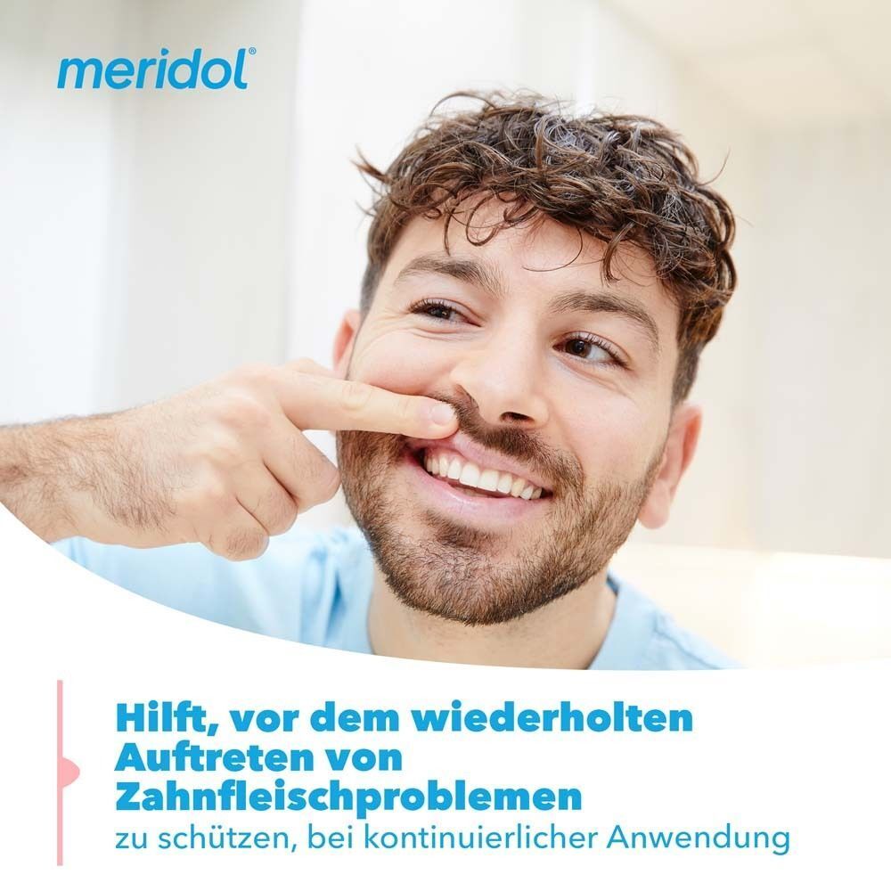 Mann zeigt auf sein Zahnfleisch, das durch Meridol vor wiederholten Problemen geschützt wird.