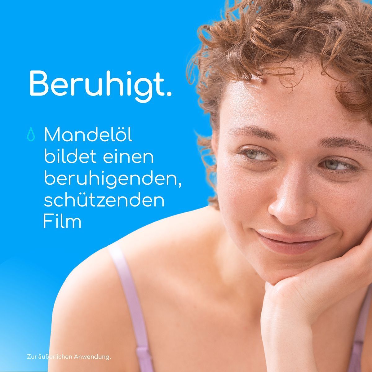Frau mit lockigem Haar lächelt, daneben Text über Mandelöl.
