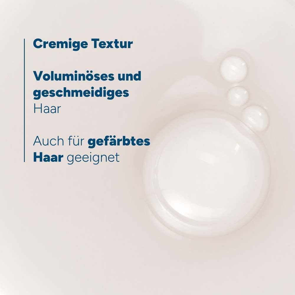 Nahaufnahme von Schaumblasen und Text über cremige Textur und voluminöses Haar.