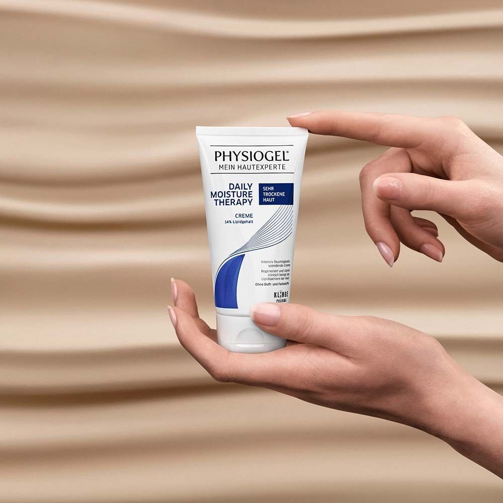 Hände halten eine Tube PHYSIogel Daily Moisture Therapy Creme.