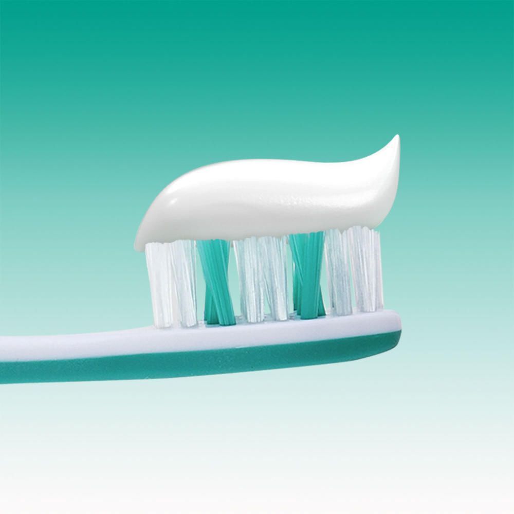 Zahnbürste mit Elmex Sensitive Sanftes Weiss Zahnpasta.