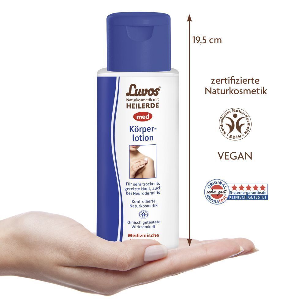 Luvos-Heilerde MED Körperlotion Flasche in einer Hand, mit Höhenangabe und Siegeln.