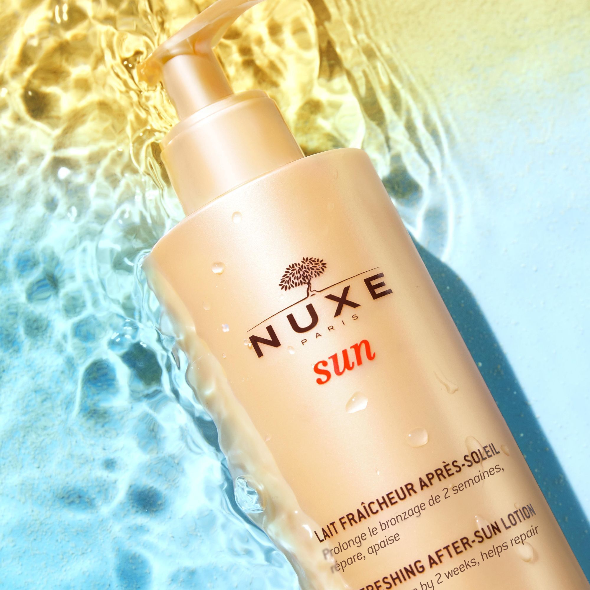 Nuxe Sun After-Sun-Milch in einer Flasche, umgeben von Wasser.