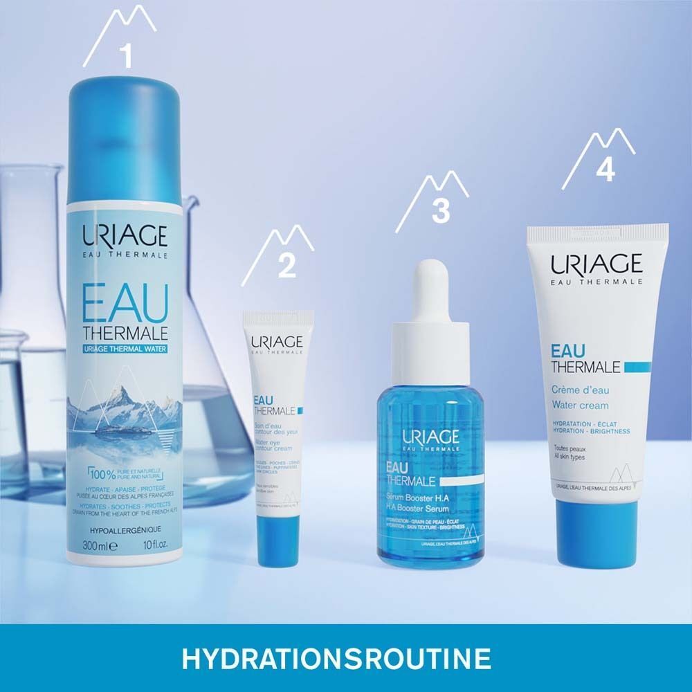 Eine Uriage Eau Thermale Thermalwasser Sprühflasche neben anderen Hautpflegeprodukten in einem Laborumfeld.