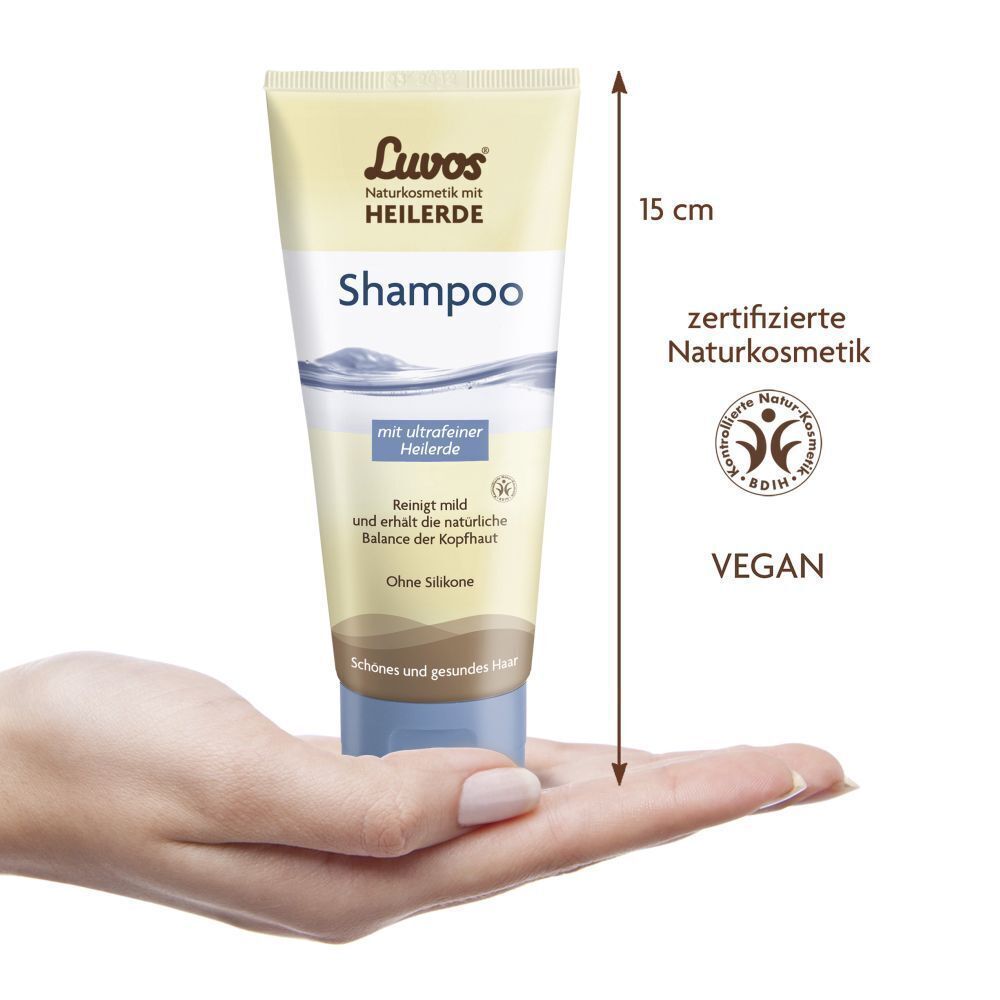 Eine Hand hält eine Tube Luvos-Heilerde Shampoo, 15 cm hoch. Zertifizierte Naturkosmetik, Vegan.