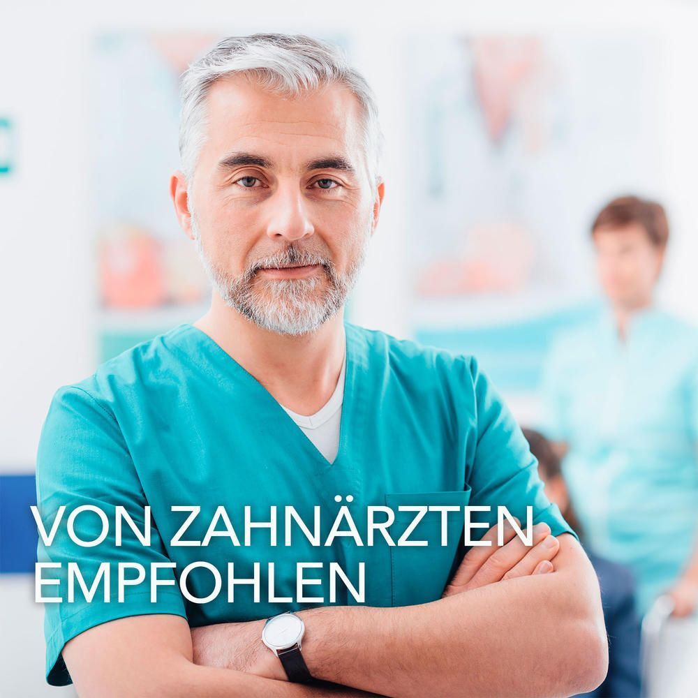 Zahnarzt in türkiser Kleidung, der mit verschränkten Armen in die Kamera blickt. Text: "VON ZAHNÄRZTEN EMPFOHLEN".