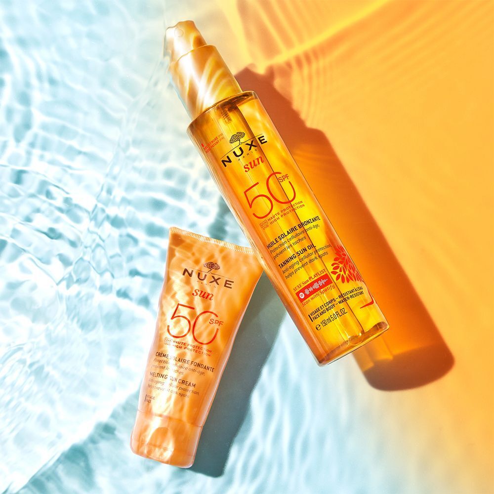 Nuxe Sun Sonnencreme Gesicht LSF 50 und Nuxe Sun Tanning Oil LSF 50 auf Wasser.
